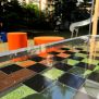 HPL Bench Chess and ludo game طاولة لعب شطرنج ولودو مع مقاعد برتقالية في الهواء الطلق.
