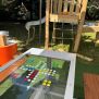 طاولة HPL Bench Chess and ludo game مع قطع ملونة للعب الشطرنج ولودو في ملعب خارجي.